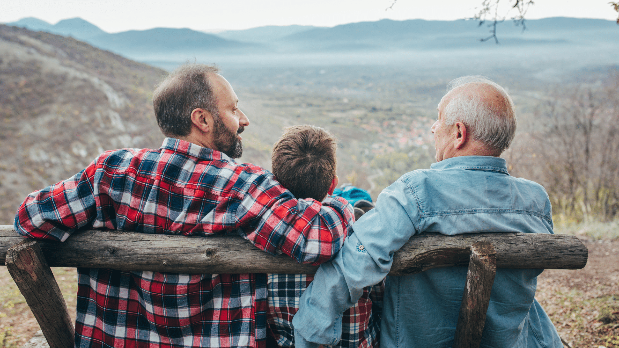 Passaggio generazionale azienda con famiglia su panchina e paesaggio di montagna